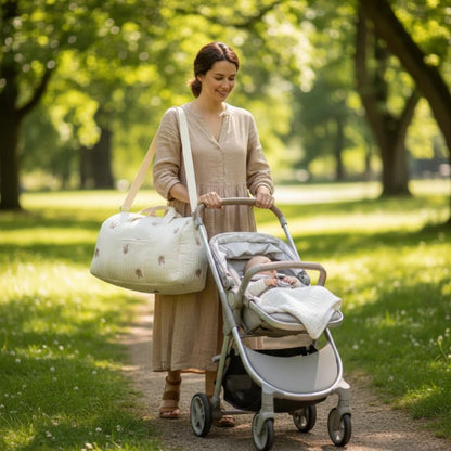 sac à langer à l'épaule maman avec une poussette dans un parc