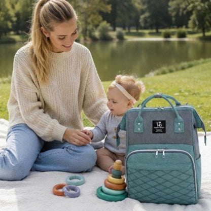 sac à langer maman assise sur l'herbe avec bébé